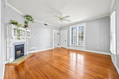 Unfurnished living room with a ceiling fan, hardw