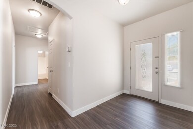 Foyer entrance with dark wood finished floors, arc