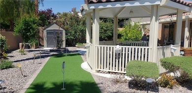 View of yard with a putting area, a storage shed,