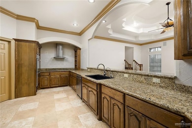 Kitchen with sink, crown molding, tasteful backsplash, light stone counters, and ceiling fan