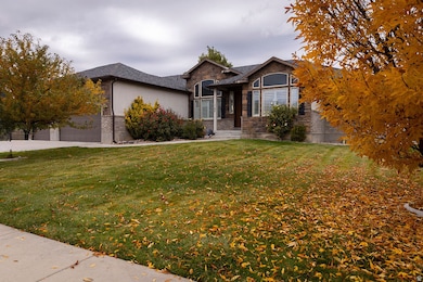 Ranch-style house with a front lawn, a garage, and stone siding