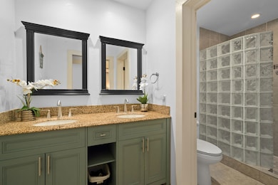 Upgraded bathroom with a snail shower and dual sinks.