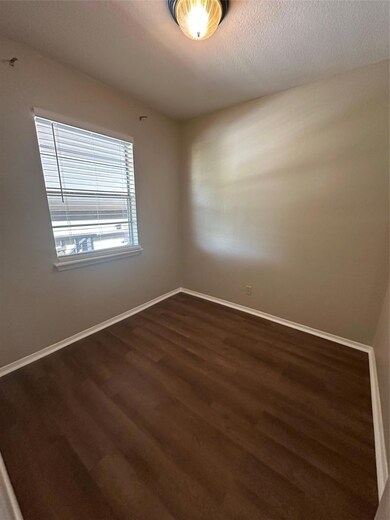 Empty room with dark wood-style flooring and base