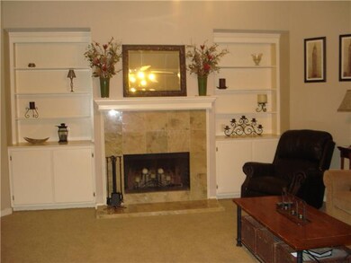 Family room with view of fireplace and built in bo