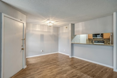 Unfurnished living room with dark wood-style flooring and a textured ceiling