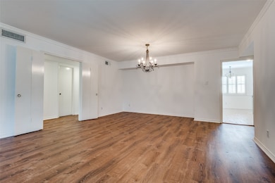 Living room with a chandelier, wood finished floors, and crown molding