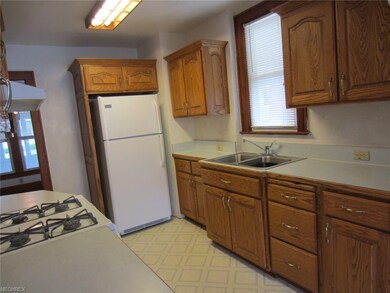 Oak cabinets with crown molding and appliances are