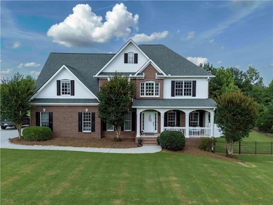 Traditional-style home featuring brick siding, a porch, and roof with shingles