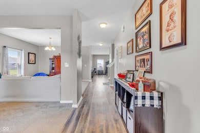 hall featuring healthy amount of natural light, a chandelier, and wood finished floors
