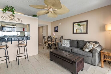 Tiled living room featuring ceiling fan and a text