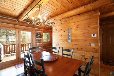 Dining room with wood ceiling, a chandelier, beame