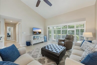 Living area with plenty of natural light, high vaulted ceiling, and a ceiling fan