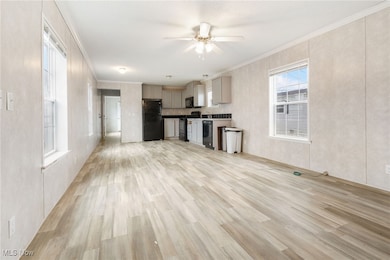 Kitchen featuring ornamental molding, gray cabinetry, black appliances, light wood-style flooring, and a ceiling fan