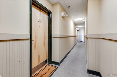 Hallway featuring a paneled ceiling and a wainscot
