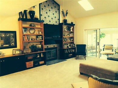 Vaulted ceiling great room with fireplace and built-in bookshelves
