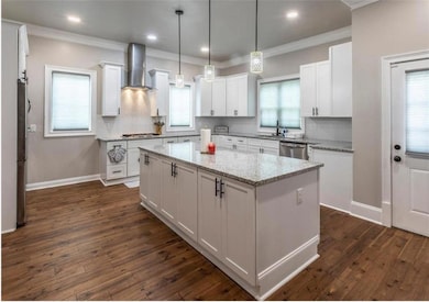 Kitchen featuring white cabinets, a center island,