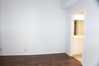 Empty room with dark hardwood / wood-style floors