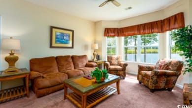 Living room featuring ceiling fan and carpet floor
