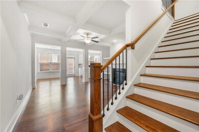 Stairs featuring coffered ceiling, beamed ceiling,