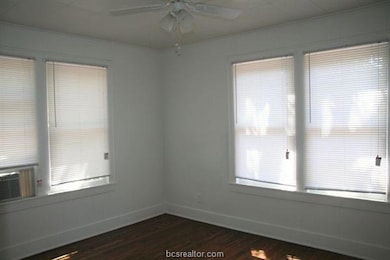 Unfurnished room with dark wood-type flooring, cei