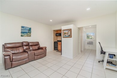 Living room with light tile patterned floors and recessed lighting