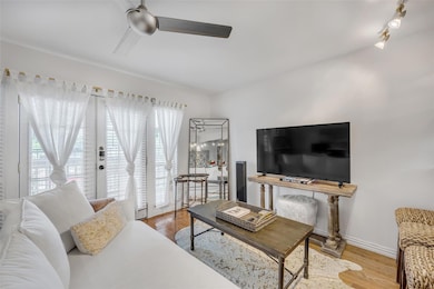 Living room featuring a ceiling fan, light wood-t