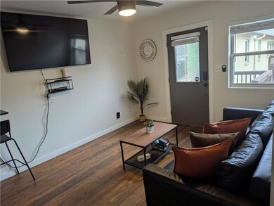 Living room with dark wood-style flooring, a ceili