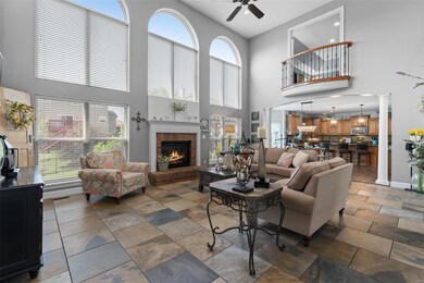 The gorgeous tile continues in your great room.  Notice the shiplap above the fireplace, wall of windows, balcony from the bonus room and the open floorplan.