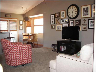 The living room is spacious with neutral carpet.