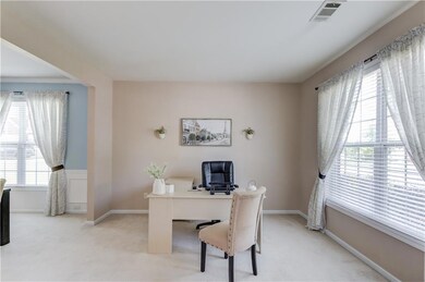 Office area featuring light carpet and baseboards