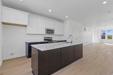 Kitchen with white cabinetry, a kitchen island with sink, light wood-type flooring, stainless steel appliances, and recessed lighting
