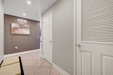 Hall with light tile patterned flooring, baseboard