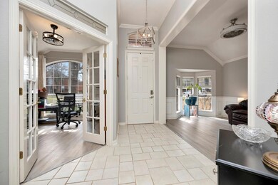 Entryway with a wainscoted wall, ornamental moldin