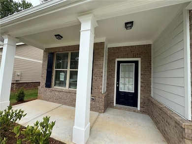 Property entrance featuring covered porch and brick siding