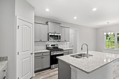 Kitchen with backsplash, an island with sink, stai