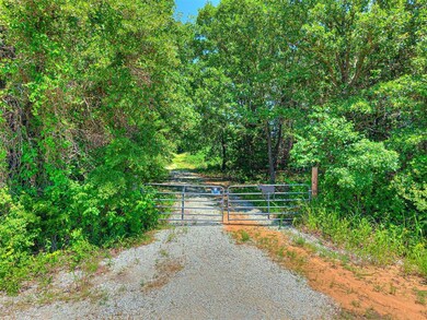 View of dirt / gravel road with a gate and a gated entry