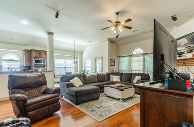 Living room with natural sunlight, hardwood floors, and lofted ceiling