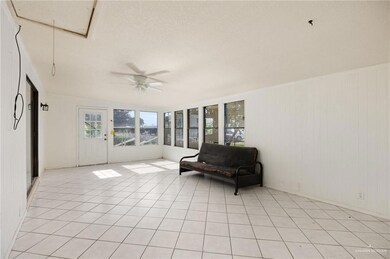 Sitting room with ceiling fan, a textured ceiling, and light tile patterned floors