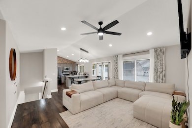 Living area featuring lofted ceiling, dark wood-style flooring, recessed lighting, and a ceiling fan