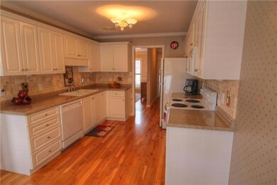Kitchen is located off dining room and living room. Features tons of cabinetry and counter space. Notice the beautiful hardwood floors. 