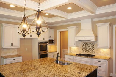 Huge center island, granite counters, double ovens, gas stove and microwave complete this gourmet kitchen. 