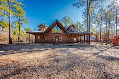 Back of property featuring log veneer siding, playground community, and a porch
