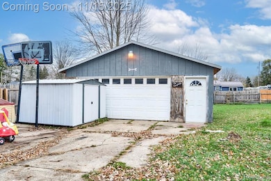 Detached garage featuring concrete driveway