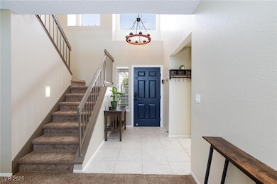Foyer entrance with stairs, a chandelier, baseboar