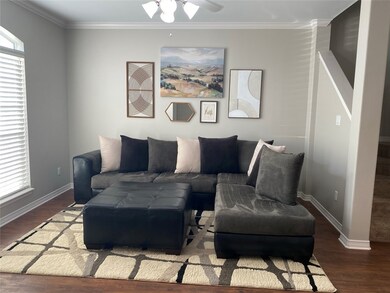 Living room with ceiling fan, crown molding, and d