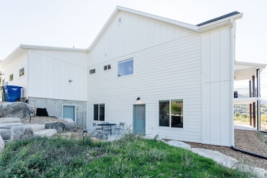 Rear view of house featuring board and batten siding and a patio