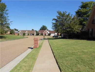 The view of surrounding homes and walking sidewalk