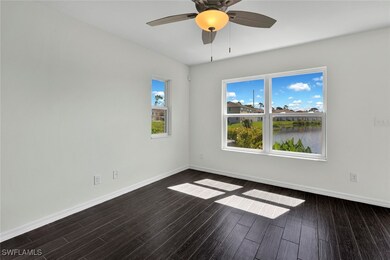 Spare room with dark wood-type flooring, a water view, and ceiling fan