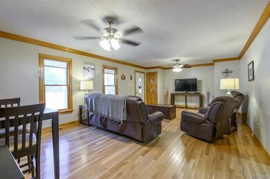 Living room with hardwood flooring, crown molding 
