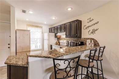 Kitchen with light stone counters, white appliance